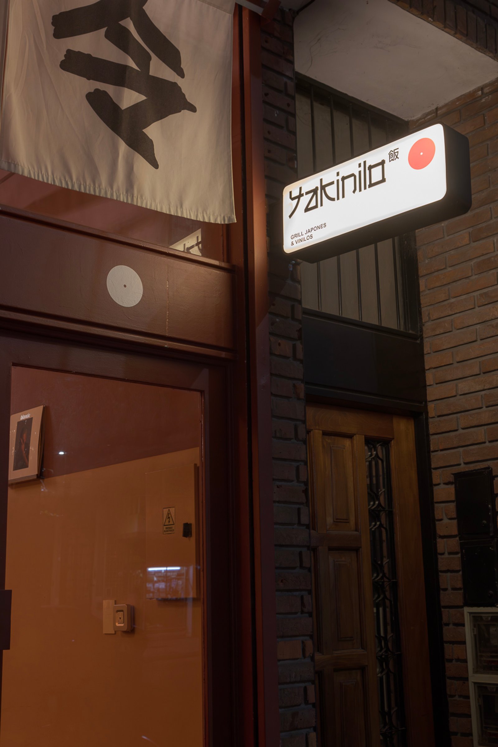 Fachada de restaurante japonés moderno con letrero luminoso — proyecto Yakinilo, por Estudio YME, en Av. Dorrego 1551